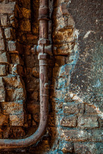 Old Rusty Water Pipe In A Brick Wall.  Old Rusty Pipe With Valves On Painted Brick Wall With Rectangle Recess. Urban Build Texture