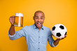 Photo of dark skin amazed guy hold hands ball beer glass support team yelling loud wear jeans denim shirt isolated bright yellow background