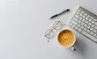 © memorystockphoto - business concept. top view of office desk workspace with keyboard, pen, glasses and hot coffee cup on white table background. over light
