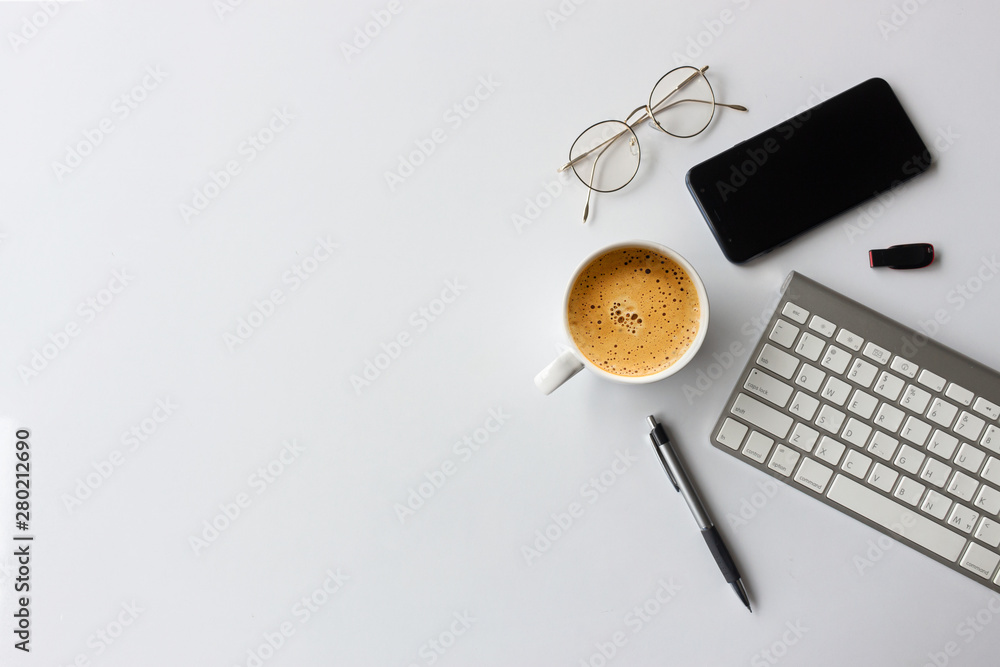 business concept. top view of office desk workspace with smartphone, pen, keyboard, glasses and hot coffee cup on white table background. over light - obrazy, fototapety, plakaty 