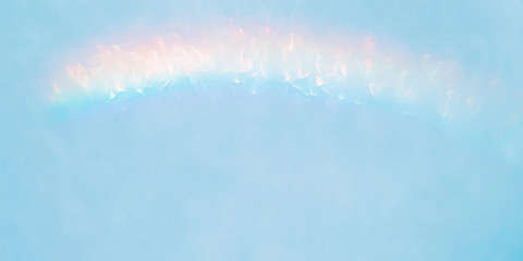 Wall Mural - iridescent holographic rainbow background. colorful lens flare bokeh texture on light blue