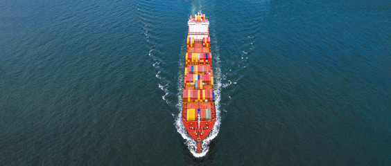 Aerial side view container ship carrying container in import export business logistic and transportation of international by container ship in the open sea, with copy space.