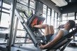 Man focused on training legs on the machine in the gym. Man in gym training at leg press to define his upper leg muscles.