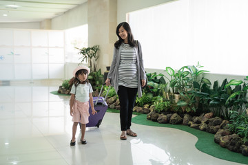 little girl and mother walking together towards the plane will go on vacation