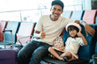 © Odua Images - happiness father and daughter smiling with thumb up look at the camera in the airport waiting room