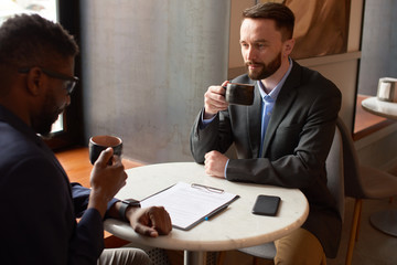 Two businessmen having a meeting in the cafe.