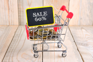 Trolley and coins with sale concept