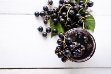 ripe black currant on a jar of jam. grocery, food preparation process