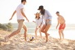 © opolja - Group of young people playing with ball at the beach. Young friends enjoying summer holidays on a sandy beach