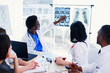 © gorynvd - Afro American doctor shows and explains MRI results to his professional team. Group of international doctors or interns have a meeting and making notes at hospital room. Health care concept.