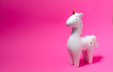 White Porcelain Unicorn Figurine On Pink Background