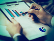 © yurolaitsalbert - Image of human hands with pens pointing at business document in