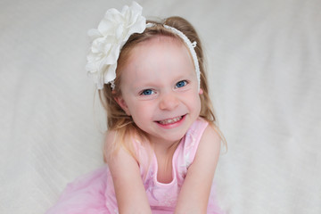 Close up portrait of Cute Blonde Toddler, 3 Years Old Girl, with Big Blue Eyes, in Pink fluffy Dress, Happy Child, The Most Beautiful Girl in the world