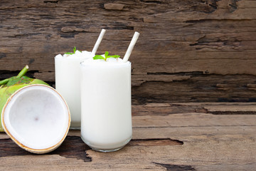 Coconut smoothies white fruit juice milkshake blend beverage healthy high protein the taste yummy In glass drink episode morning on a wooden background.