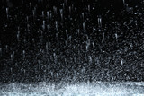 Fototapeta  - Heavy rain falling down on ground against dark background
