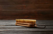 Shoe brush on wooden table. Footwear care item