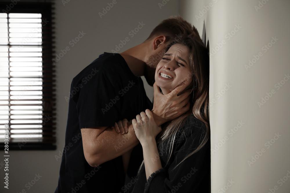 Man choking young woman indoors. Stop sexual assault - obrazy, fototapety, plakaty 