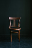Fototapeta  - Old-fashioned wooden chair on a dark background in the interior