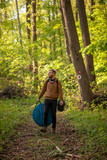 Fototapeta Na ścianę - One young man, in forest alone, trekking, walking. Carrying camp
