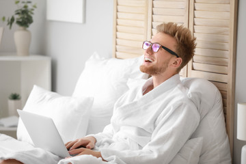 Canvas Print - Morning of young man with laptop in bedroom