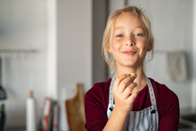 Funny Girl In Apron Eating Handmade Cookie