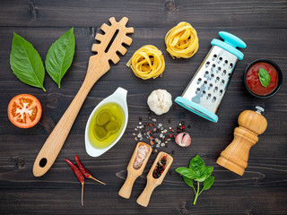 Wall Mural - The  pasta on black wooden background. Yellow italian pasta with ingredients. Italian food and menu concept.