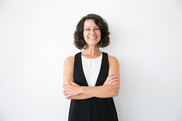 Happy joyful woman in casual posing over white studio background. Portrait of cheerful successful middle aged business lady with arms folded smiling at camera. Female portrait concept
