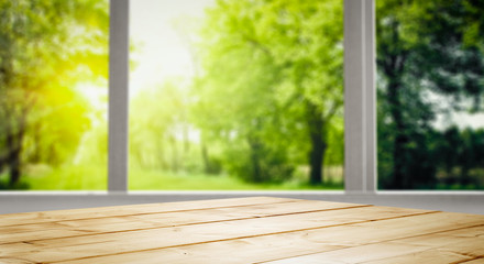 Table background and spring time. Green nature in blurred view in distance. Empty space for decoration and an advertising product.