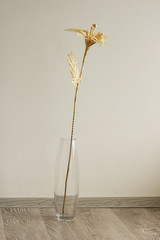 Bouquet of flowers made of straw in a glass vase