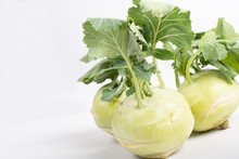 Three Pieces Of Kohlrabi Vegetable Isolated On Yellow Simple Background With Copy Space. Green Leafy Vegetable From Cabbage And Radish Family, Bio And Organic Grown From The Garden