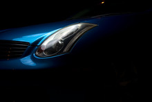  Headlight Car. Headlight Blue Sports Car. Part Of The Blue Car On A Dark Background.