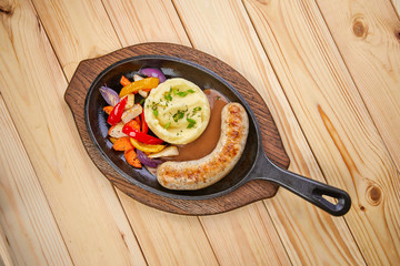 Wall Mural - sausage with mashed potato and vegetables, wooden background