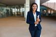 © Mangostar - Cheerful businesswoman with digital tablet. Beautiful happy young woman holding tablet pc and smiling at camera in office building. Technology concept