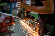 Handwerker schneidet Metallrohr mit der Trennscheibe unter leuchtendem Funkenflug