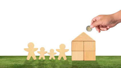 Wall Mural - male hand is placing a money coin on the wooden house. have doll , shape father mother and boy girl. Saving concept to build a house and a happy family