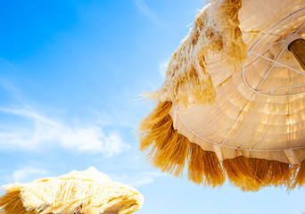 Wall Mural - View from below of beautiful thatched umbrellas on the beach.