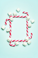 Christmas Layout With Candy Cane And Different Sizes Marshmallows On A Turquoise Background In The Form Of Square Shape. Concept For New Year Postcard With Space For Text.