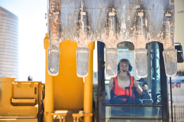 Woman in reflective clothing operating heavy excavator equipment