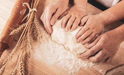 children's hands and the hands of his mother and knead dough together