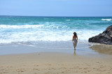 Fototapeta Konie - Woman with a Dress Walking Alone by an Empty Beach in Fuerteventura