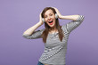 © ViDi Studio - Young brunette woman girl in casual striped clothes posing isolated on violet purple background studio portrait. People sincere emotions lifestyle concept Mock up copy space Listen music in headphones