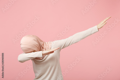 Cuadros en Lienzo Young arabian muslim woman in hijab light clothes posing isolated on pink wall background studio portrait