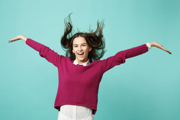 Young brunette woman girl in casual clothes posing isolated on blue green turquoise background studio portrait. People sincere emotions lifestyle concept. Mock up copy space. Fluttering waving hair.