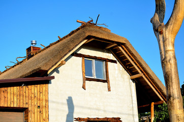 Ecological construction, the house in the national style with a roof of reeds.