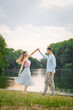 © Sunshine - Stylish and romantic guy and girl dancing on the lake on a summer evening. They are happy and smiling at each other