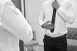 © Pavlo - The groom straightens tie before the wedding ceremony on his wedding day, black and white photo