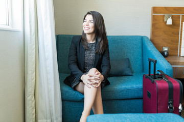 Wall Mural - Smiling Businesswoman With Suitcase Sitting In Hotel Room