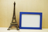 Fototapeta Boho - Space photo frame mock up with Eiffel tower souvenir on wooden background