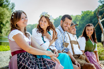 Wall Mural - Five friends, men and women, having fun on Bavarian RIver and clinking glasses with beer