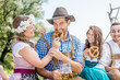 © karepa - Friends in Bavarian costume celebrate on the river Isar and drink beer. Oktoberfest munich